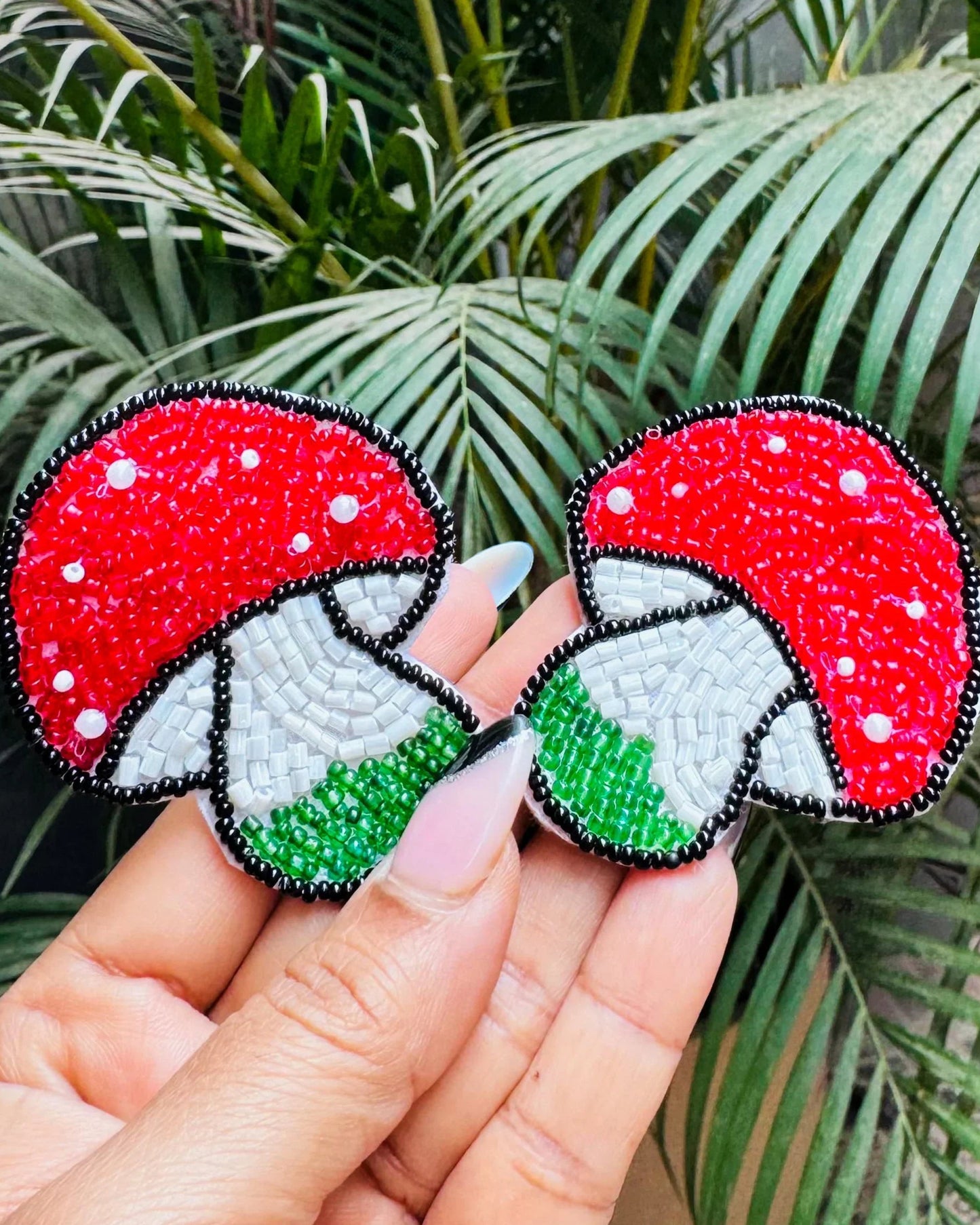 Two red and green mushroom-shaped beaded earrings