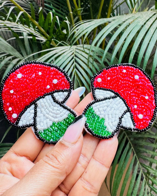 Two red and green mushroom-shaped beaded earrings